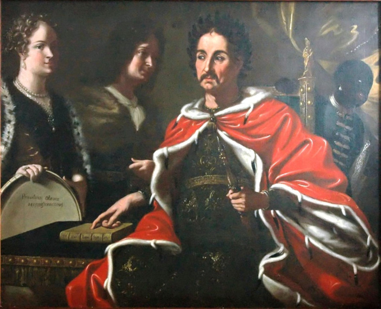 Olej na Płotnie. Obraz przedstawia scenę kiedy Jan III Sobieski przekazuje synowi Jakubowi prawo do korony. Na pierwszym planie widzimy Jana III w królewskim płaszczu i wieńcu laurowym. Prawą ręką wskazuje on na leżącą przy nim Biblię. Na drugim planie, po lewej stronie, stoi Jakub Ludwik z żoną Jadwigą Elżbietą, która trzyma w rękach owalne lustro – znak, że cechy królewicza są odblaskiem wybitnych cnót ojca. Obraz pełen jest symbolicznych odniesień do idei dziedziczenia tronu królewskiego przez Jakuba Ludwika Sobieskiego.