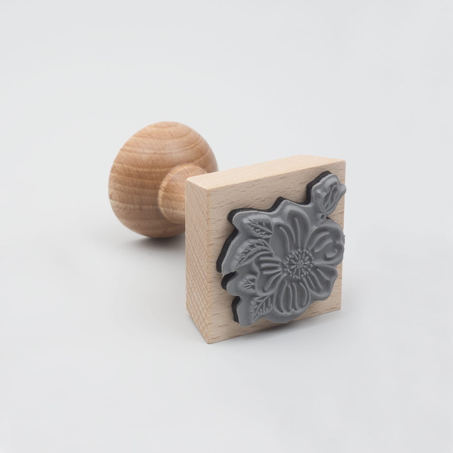 Drewniany stempel z pieczątką w kształcie kwiatka. 