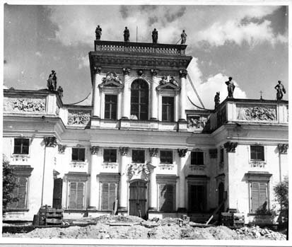 Czarno-białe zdjęcie archiwalne. Przedstawia Korpus Główny Pałacu w trakcie prac konserwatorskich w 1955 rok. 
